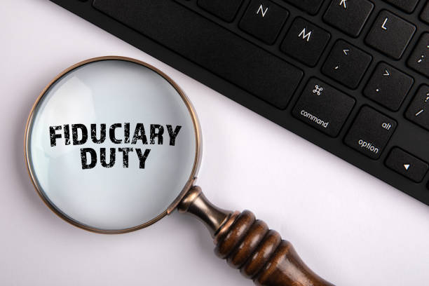 istock FIDUCIARY DUTY. Magnifying glass and computer keyboard on a white background 1446218140