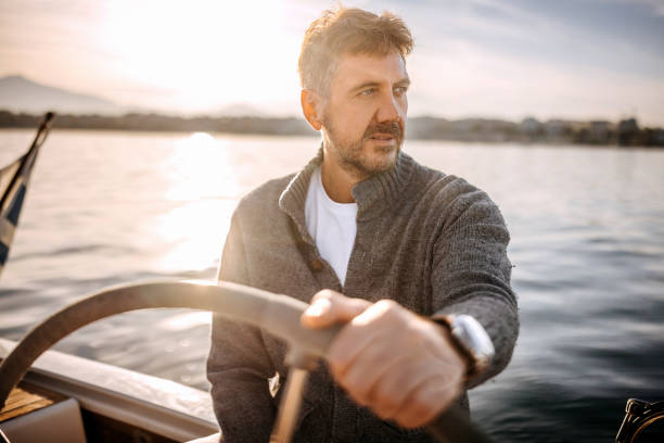 istock Handsome mature man sailing his yacht on vacation 1446218165