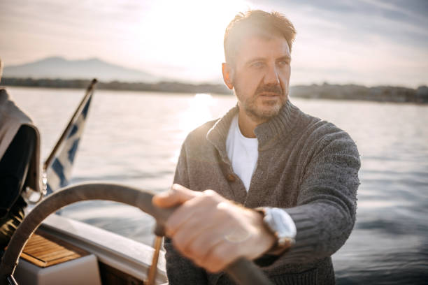 Handsome mature man sailing his yacht on vacation