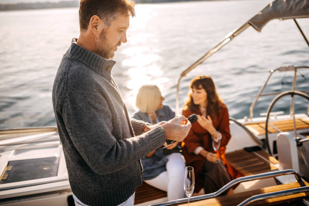 istock Mature man opening champagne bottle on yacht 1446218575