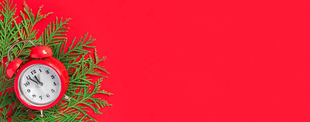 istock Alarm clock  with tree branches on red paper background. 5 minutes before the New Year. Creative greeting card. 1446219597