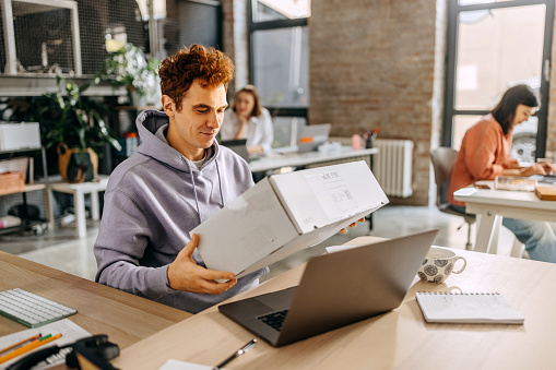 Man opening delivery box that he ordered online in the office