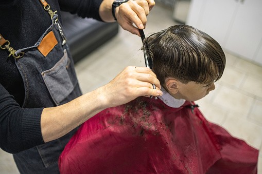 Barber cutting little boy's hair