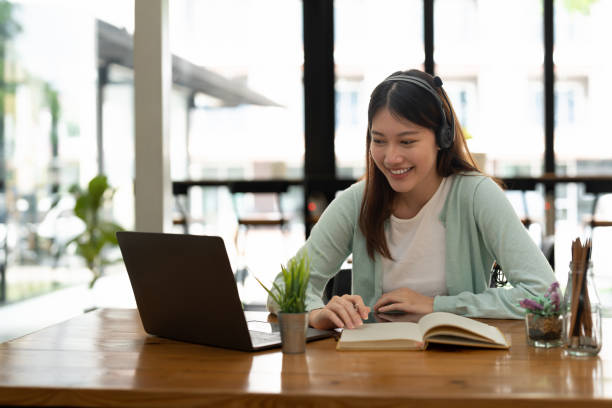 istock Asian woman writing making list taking notes in notepad working or learning on laptop indoors- educational course or training, seminar, education online concept 1446221873