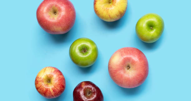 istock Various types of apples on blue background. 1446223389