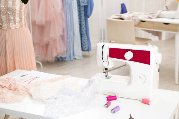 istock Modern sewing machine with fabric and bright threads on table in dressmaking workshop 1446223699