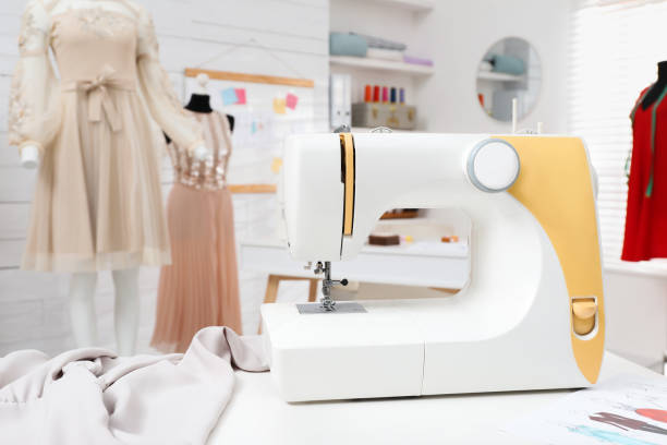 istock Modern sewing machine, fabric and accessories on table in dressmaking workshop 1446224935