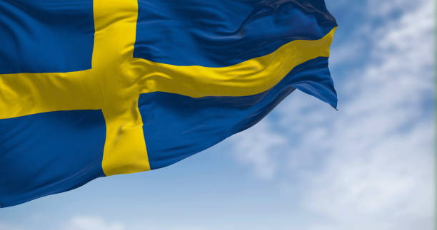 close-up view of the sweden national flag waving in the wind - day sky swedish flag banner imagens e fotografias de stock