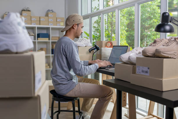 istock Asian male e-commerce business owner working on laptop computer in store warehouse. 1446232370
