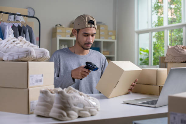 istock Asian man business owner scanning barcode on delivery parcel. 1446232409