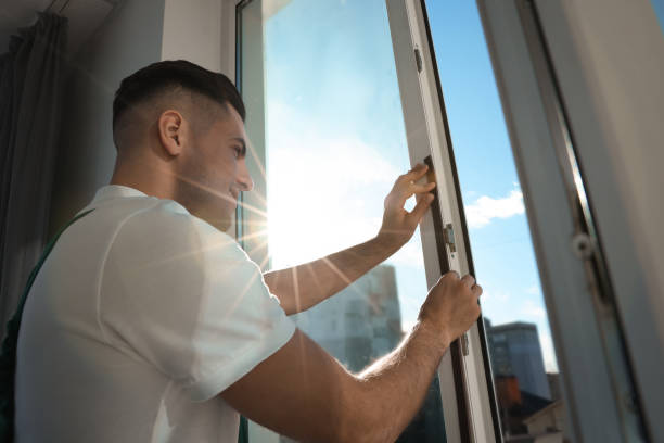 istock Man putting rubber draught strip onto window indoors 1446234317