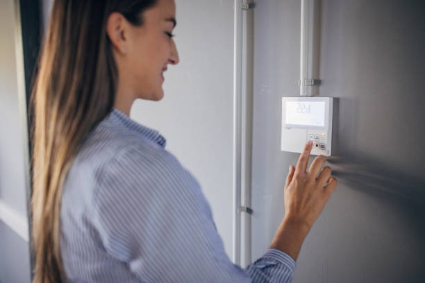 istock Young woman changing temperature on thermometer in the office 1446239081