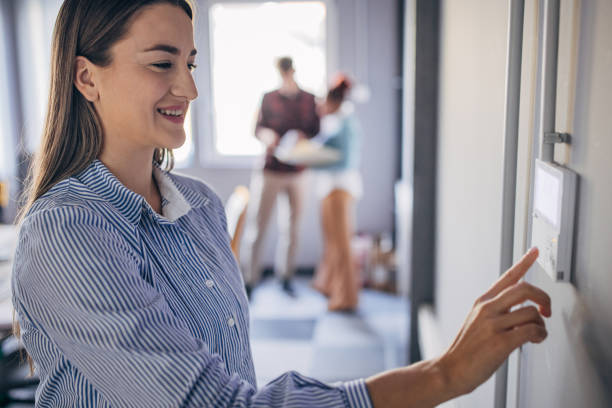 istock Young woman changing temperature on thermometer in the office 1446239208