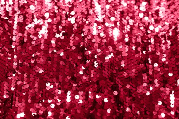 Photo of Beautiful festive background with magenta sequins. Color of 2023. Viva. Magenta.