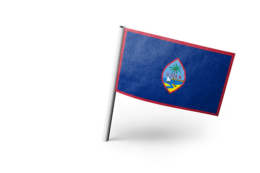 Small paper flag of Guam pinned. Isolated on white background. Horizontal orientation. Close up photography. Copy space.