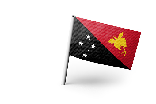Small paper flag of Papua New Guinea pinned. Isolated on white background. Horizontal orientation. Close up photography. Copy space.