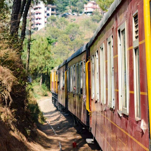 istock Toy Train moving on mountain slopes, beautiful view, one side mountain, one side valley moving on railway to the hill, among green natural forest. Toy train from Kalka to Shimla in India, Indian Train 1446250078