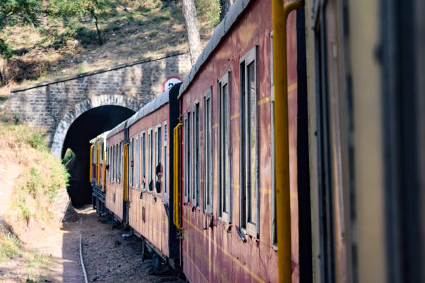 istock Toy Train moving on mountain slopes, beautiful view, one side mountain, one side valley moving on railway to the hill, among green natural forest. Toy train from Kalka to Shimla in India, Indian Train 1446250079
