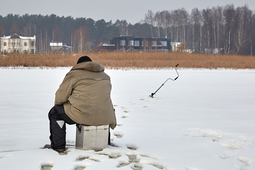 January 21, 2021, Baltezers, Latvia: fisherman on a frozen lake from a back side