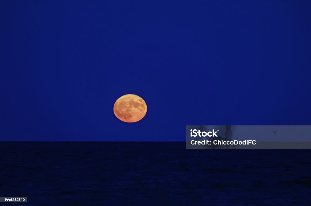 red full moon over the calm sea red full moon over the calm evening sea Astrology Stock Photo