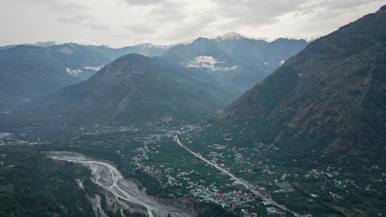 Forest and towns of Himalayas, clouds and fog, aerial drone shot