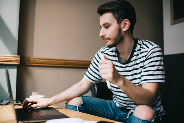 istock Young man working on laptop and clicking pen 1446263751