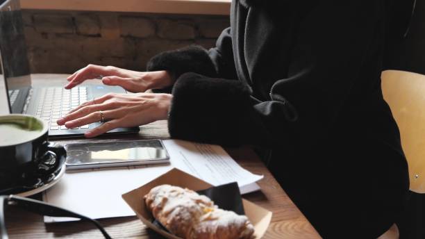 istock Concentrated female student or freelancer working in notebook, coffee cup in wooden table in cafe 1446266250