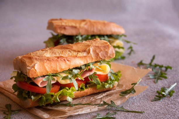 istock Baguette sandwich with cheese, ham, tomatoes and vegetables 1446267034