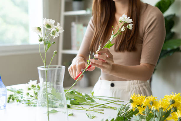 istock young woman arranging flower on the table 1446267237