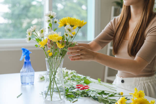 istock young woman arranging flower on the table 1446267240