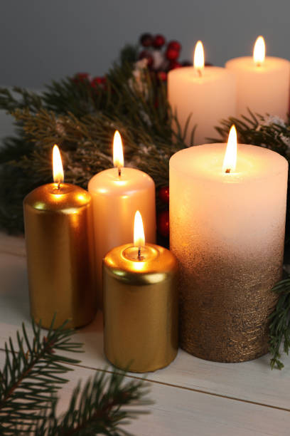 istock Different burning candles and Christmas decor on white wooden table 1446267275