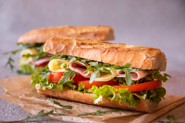 istock Baguette sandwich with cheese, ham, tomatoes and vegetables 1446267457