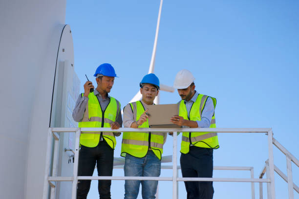 istock Blue collar workers at electricity site. Windmill field. 1446269225