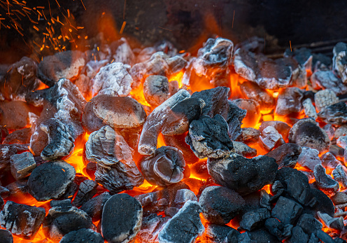 Charcoal and embers burning at full capacity at its peak in a metal barbecue