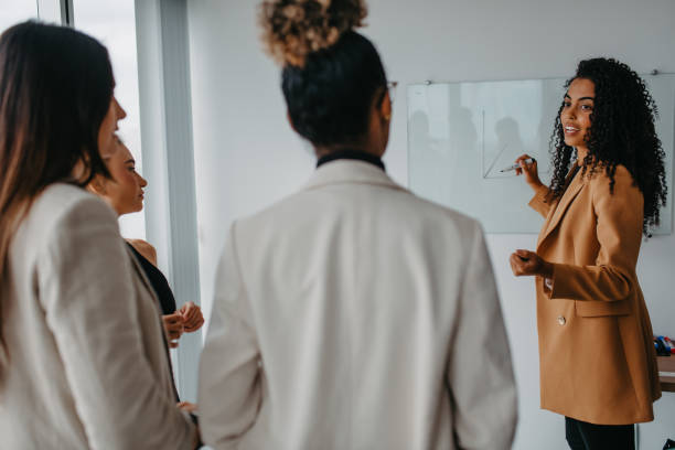 istock woman presenting information to coworkers 1446274004