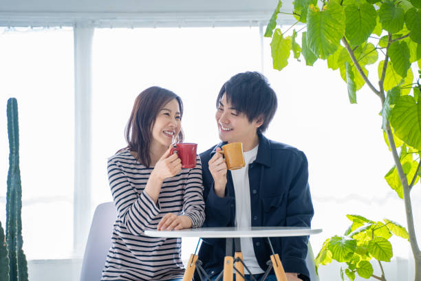istock Young smiling conversational couple drinking coffee in bright living room 1446275852