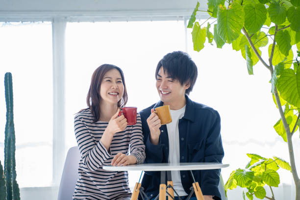 istock Young smiling conversational couple drinking coffee in bright living room 1446276030