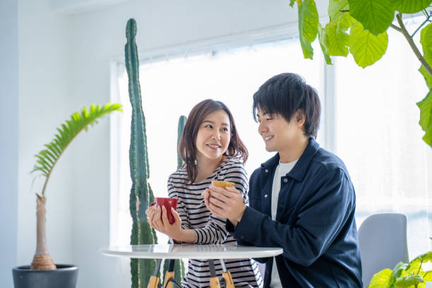 istock Young smiling conversational couple drinking coffee in bright living room 1446276864