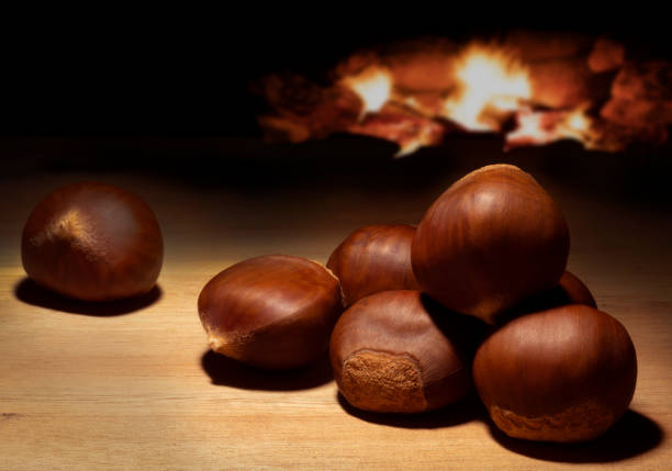 fuoco dietro una partita di castagne su un tavolo - chestnut sweet food yellow group of objects foto e immagini stock