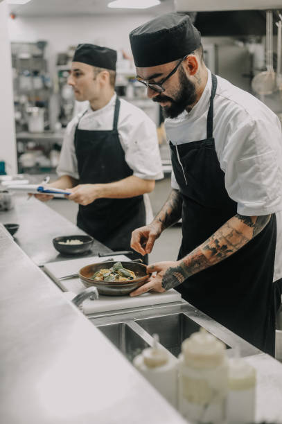 chef working in a high end restaurant kitchen - 2 chefs imagens e fotografias de stock