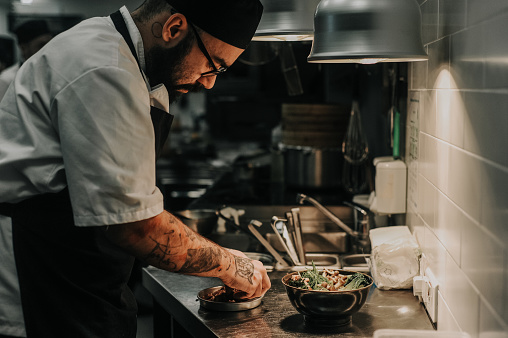 chef plating up in a restaurant kitchen