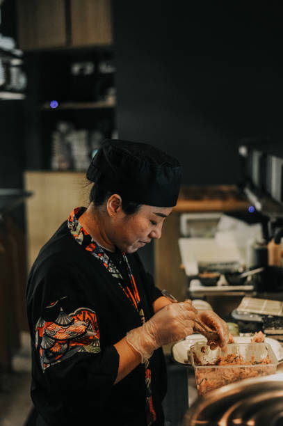 istock Thai female chef preparing food in restaurant kitchen 1446277901