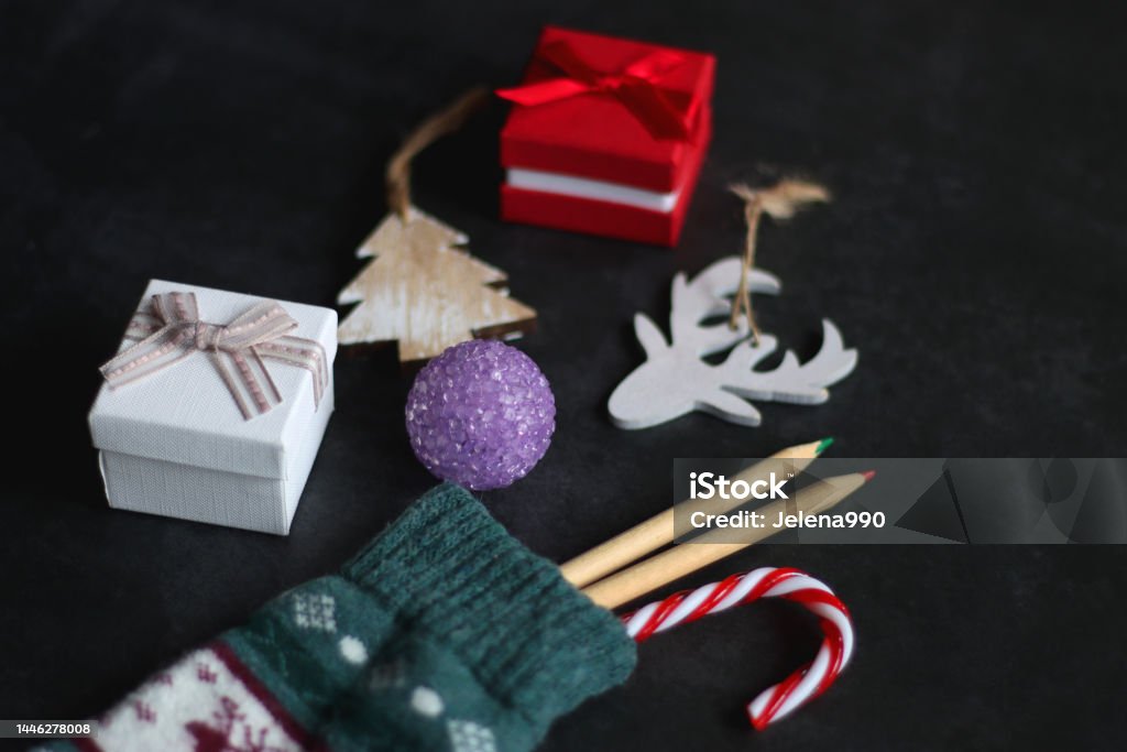 Stocking with Toys and Presents Christmas stocking filled with decorations, small presents, sweets and toys. Dark background, selective focus. Christmas Stocking Stock Photo