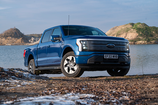 Berlin, Germany - 21 November, 2022: Electric pick-up truck Ford F-150 next to the lake. This model is the most popular pick-up vehicle in North America.
