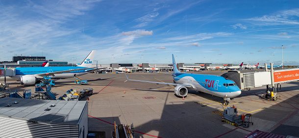Amsterdam, Netherlands - October 19, 2022: A panorama picture of multiple planes at the Schiphol Airport.