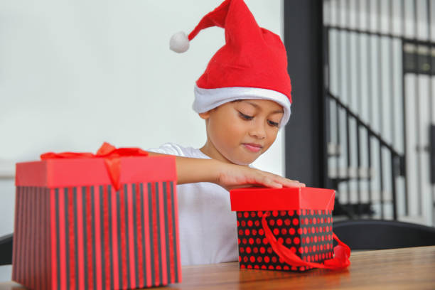 istock Cute Little Boy Opening Christmas Gift 1446286290