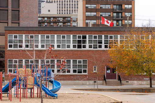 Ottawa, Canada - November 6, 2022: School building and schoolyard in downtown district of the city. Canadian school with playground in the yard.