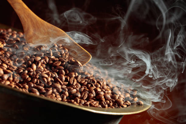 Coffee beans are smoky in a roasting pan. stock photo