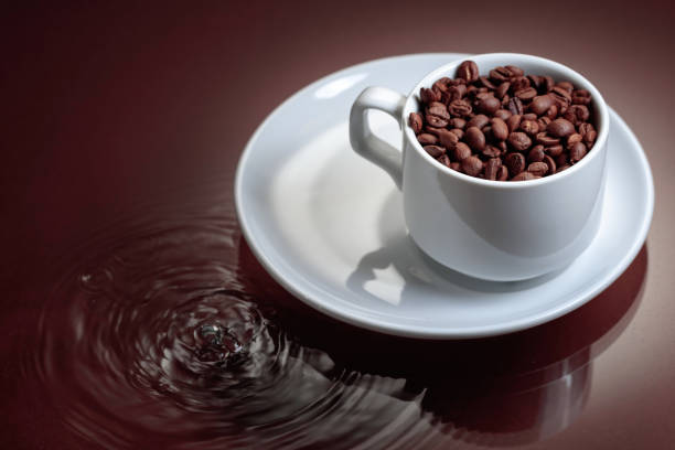 istock Cup with coffee beans on a brown background. 1446288853