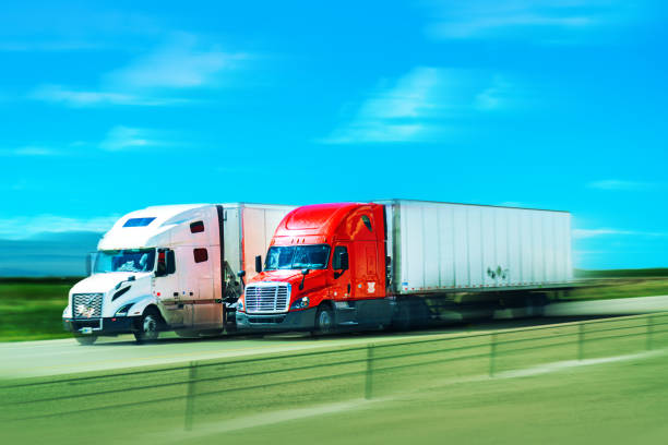 istock Red and white semi-trucks driving side by sidein Texas - motion blur 1446290591